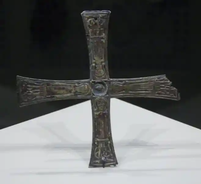 Copper-alloy cross, man forming a cross
